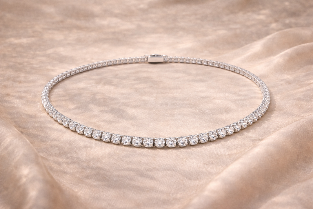 Silver necklace with clear stones on a beige fabric background