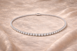 Load image into Gallery viewer, Silver necklace with clear stones on a beige fabric background